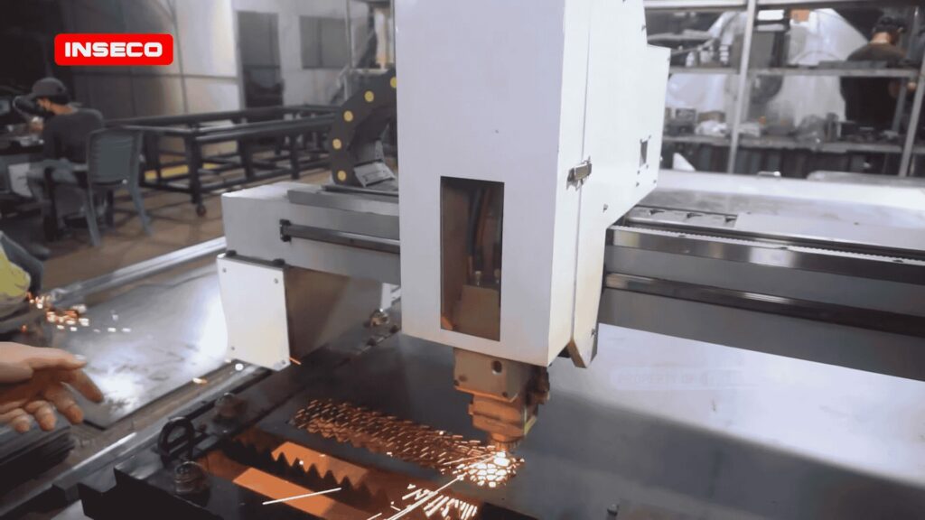 Mesin fiber laser CNC sedang digunakan untuk memotong logam, tampak operator sedang mengontrol mesin dengan hati-hati untuk memastikan hasil yang presisi