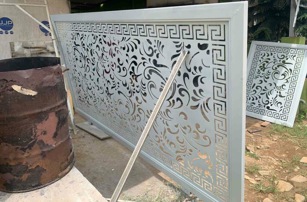 Desain pagar cutting laser dengan pola ornamen elegan, terlihat potongan yang rapi pada bahan besi, memberikan kesan modern dan artistik