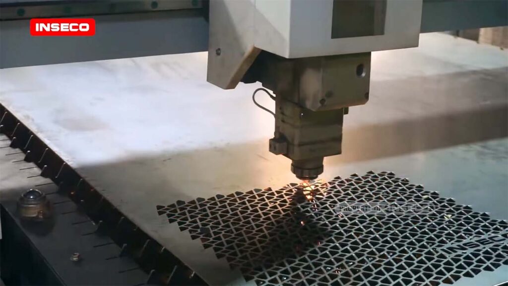 Proses pemotongan laser pada plat logam menggunakan mesin CNC fiber laser untuk menciptakan desain grill speaker kustom dengan presisi tinggi