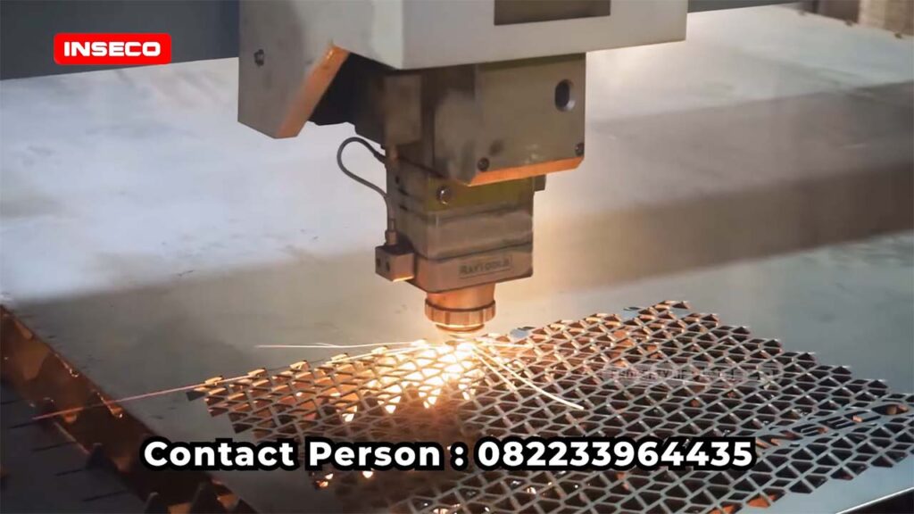 Detail close-up dari pemotongan laser yang sedang berlangsung, menghasilkan pola berlubang yang akurat untuk aplikasi grill speaker